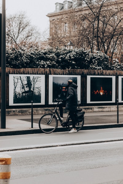 The man in black jacket during the day on the road to ride a bicycle
